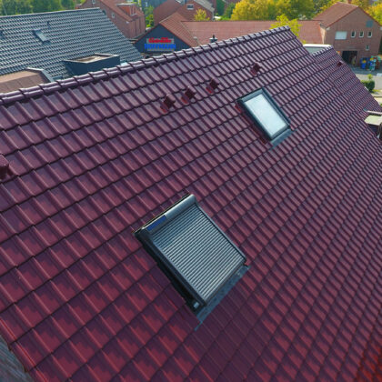 Mehrfamilienhaus aus der Vogelperspektive mit Flachdachziegel J11v in edelweinrot. Im Fokus das tolle Deckbild.