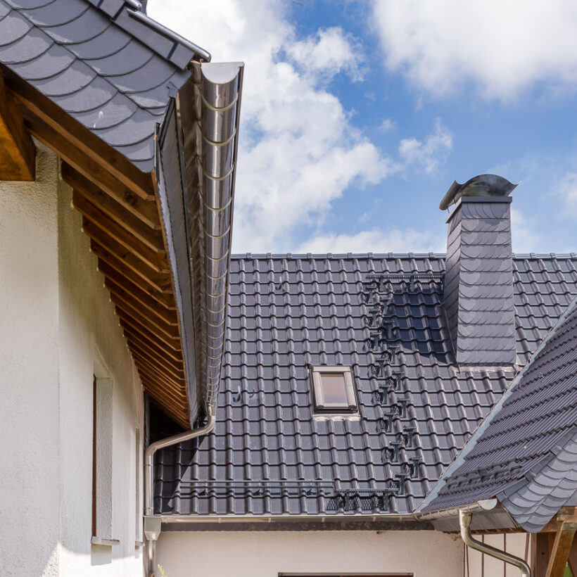 Einfamilienhaus mit Holz und Flachdachziegel J11v in spacegrau aus dem nichtkeramischen Zubehör Kurztritt, Langrost und Doppelrohrhalterung