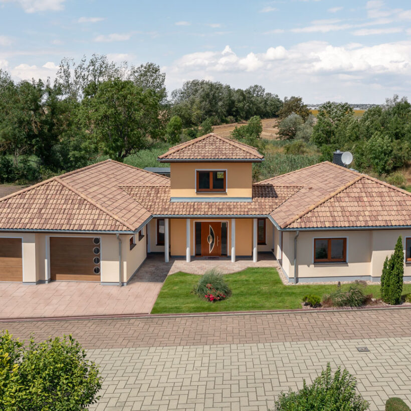 Bungalow i middelhavsstil med romansk pande Marko Bella Casa med murstensdetaljer.