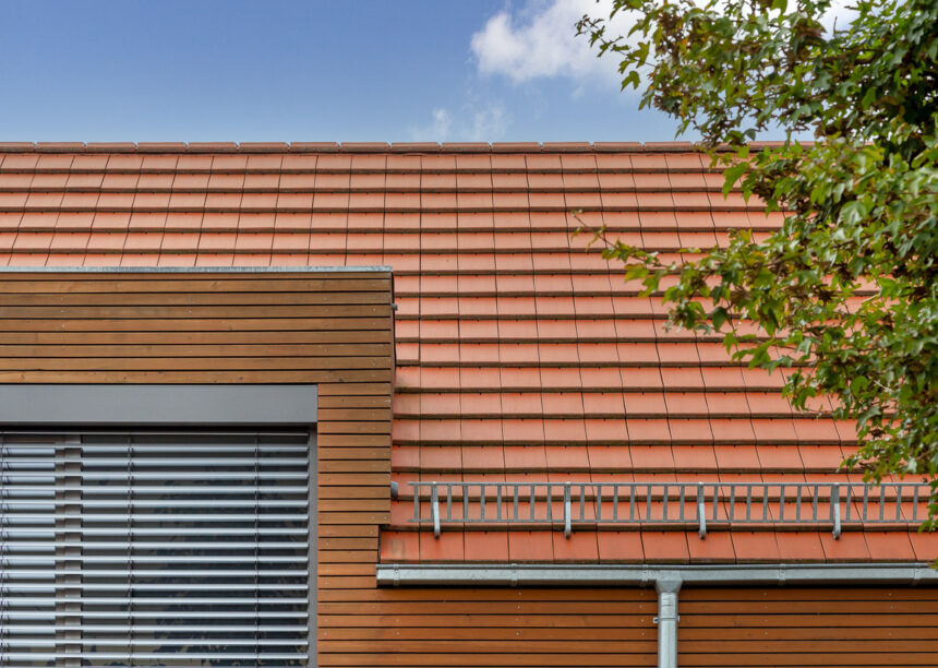 Parcelhus med træelementer og WALTHER Stylist flade tegl i rødbrun på taget