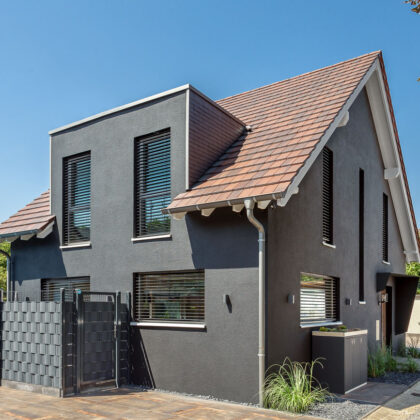 Traumhaus mit dunkler Fassade und Flachziegel in cottage in der Gesamtansicht