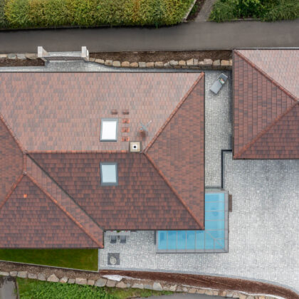 Zicht in vogelvlucht op schilddak met stylist in cottage.